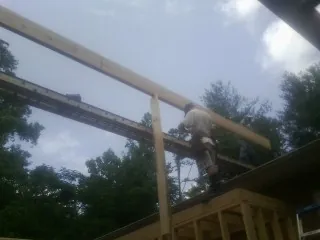 Carpenter setting a ridge beam over a new addition frame — Ice Dam Removal by Roofing Brothers in Latonia