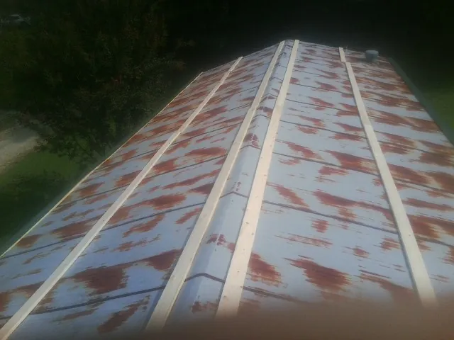 Rusted metal roof panels with new wood purlins before replacement — Storm Damage Roof Repair in Latonia by Roofing Brothers