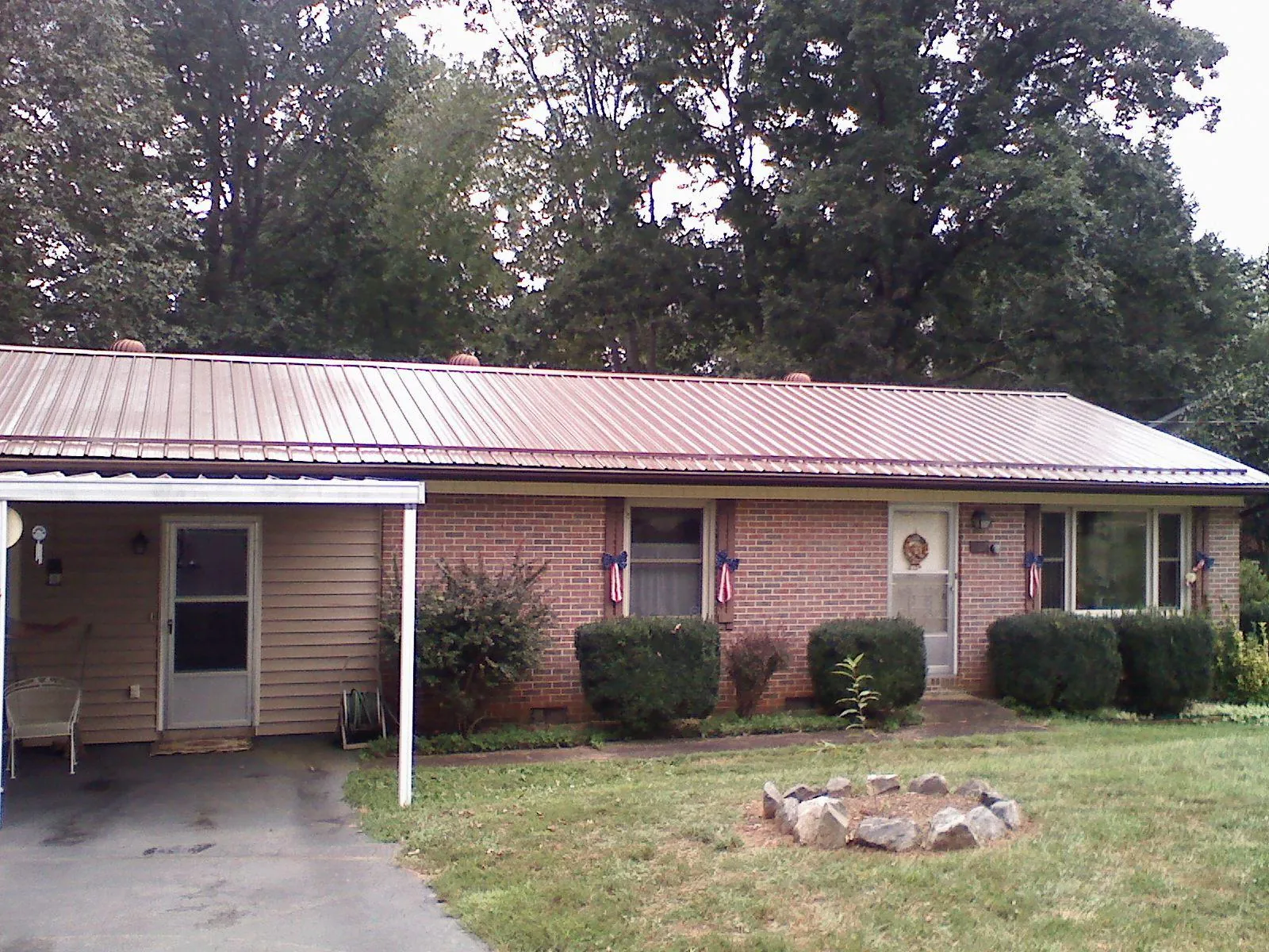 Bronze metal roof and carport on a brick ranch home — Roof Repair work by our crew in Latonia